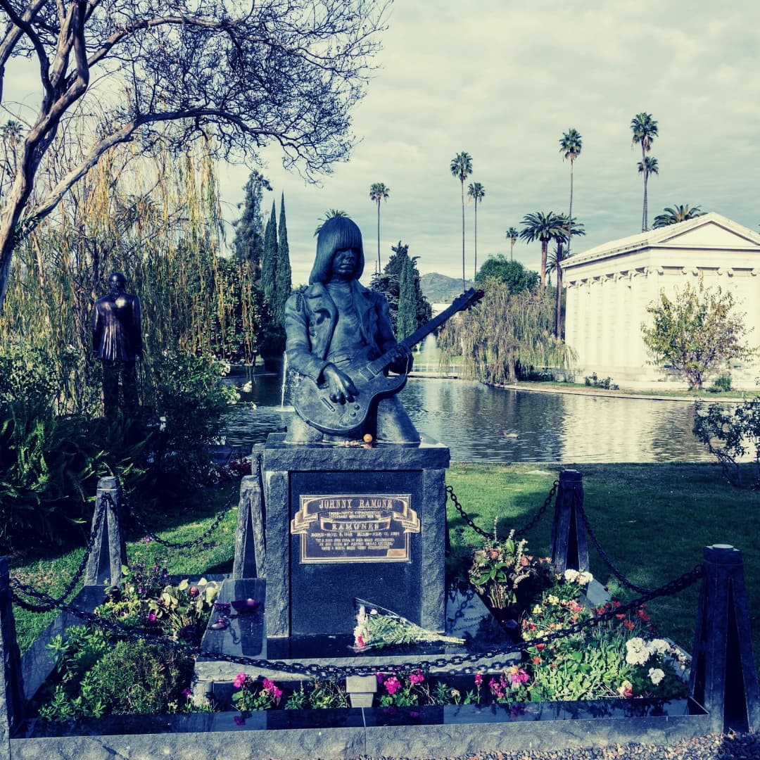 Hollywood forever cemetery has a statue of a man holding a guitar