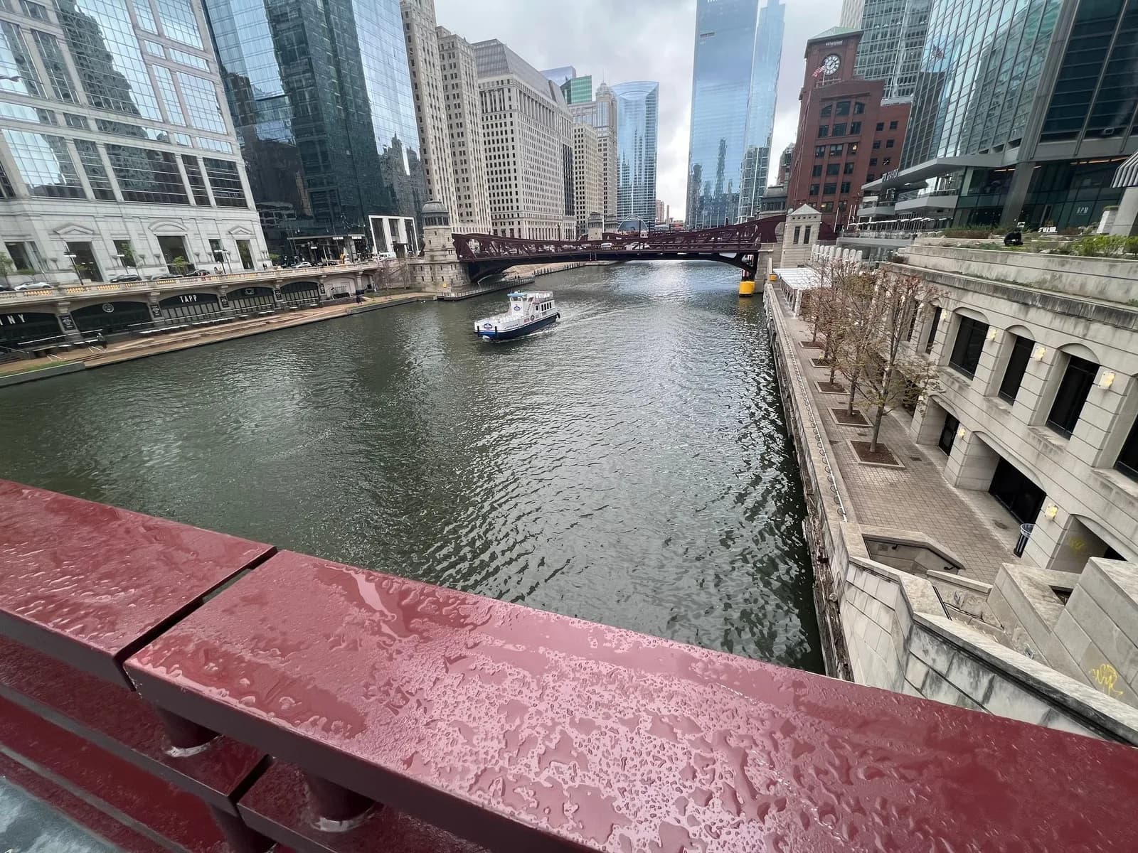 A boat is going down a river in a city