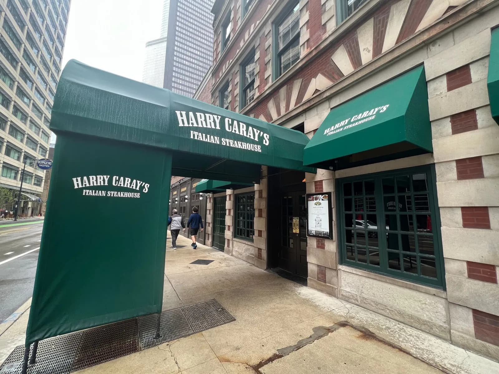 A restaurant with a green awning that says harley davidson