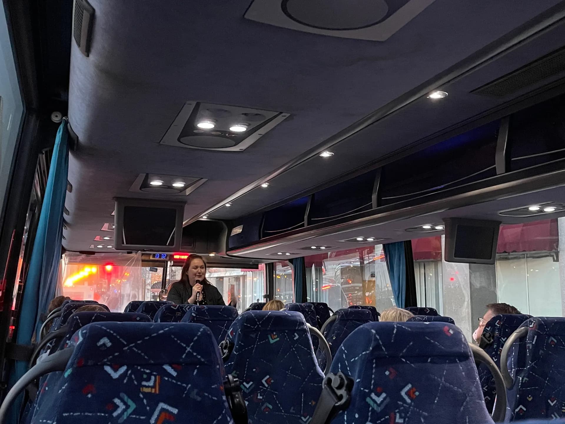 A guide narrating ghost stories aboard the Original Chicago Hauntings luxury coach bus tour