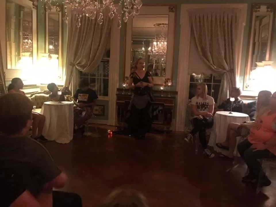Guide telling ghost stories in a Lake Geneva ballroom