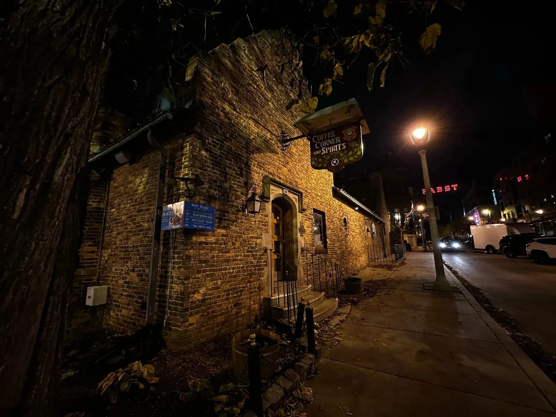 Historic brick building with Coffee Corner and Spirits sign at night