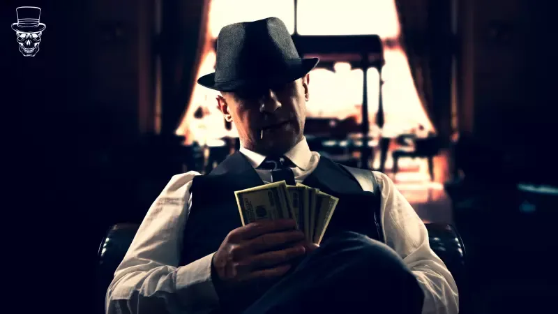 A man in a hat is holding a bunch of money.