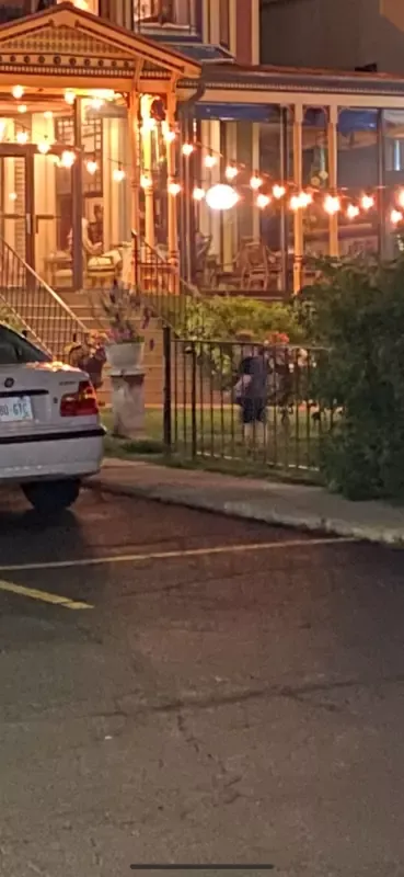 A white car is parked in front of a building at night.