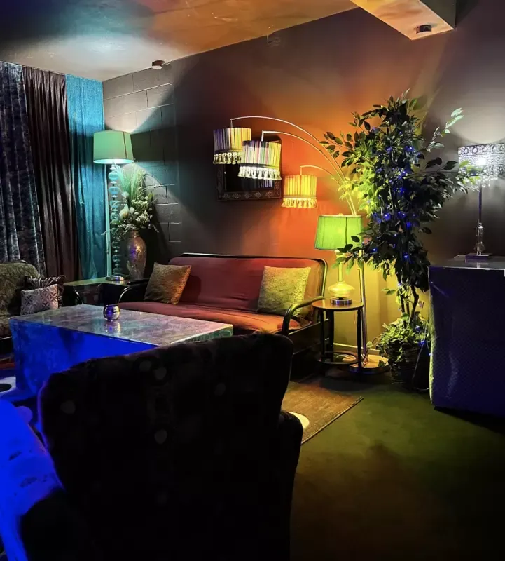 A living room with a couch , chair , table and lamps.