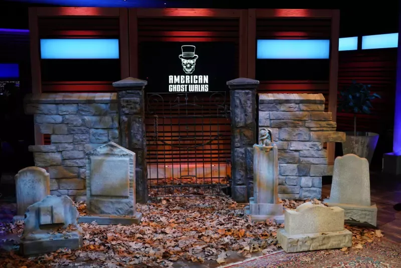 A cemetery with graves and a gate in front of a building.