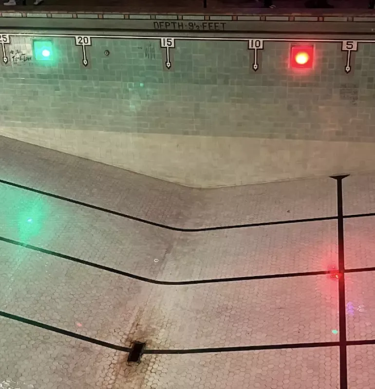 A red and green light is hanging from a pole