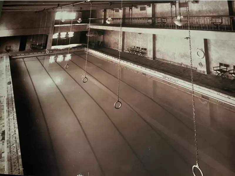 A large swimming pool with rings hanging from the ceiling