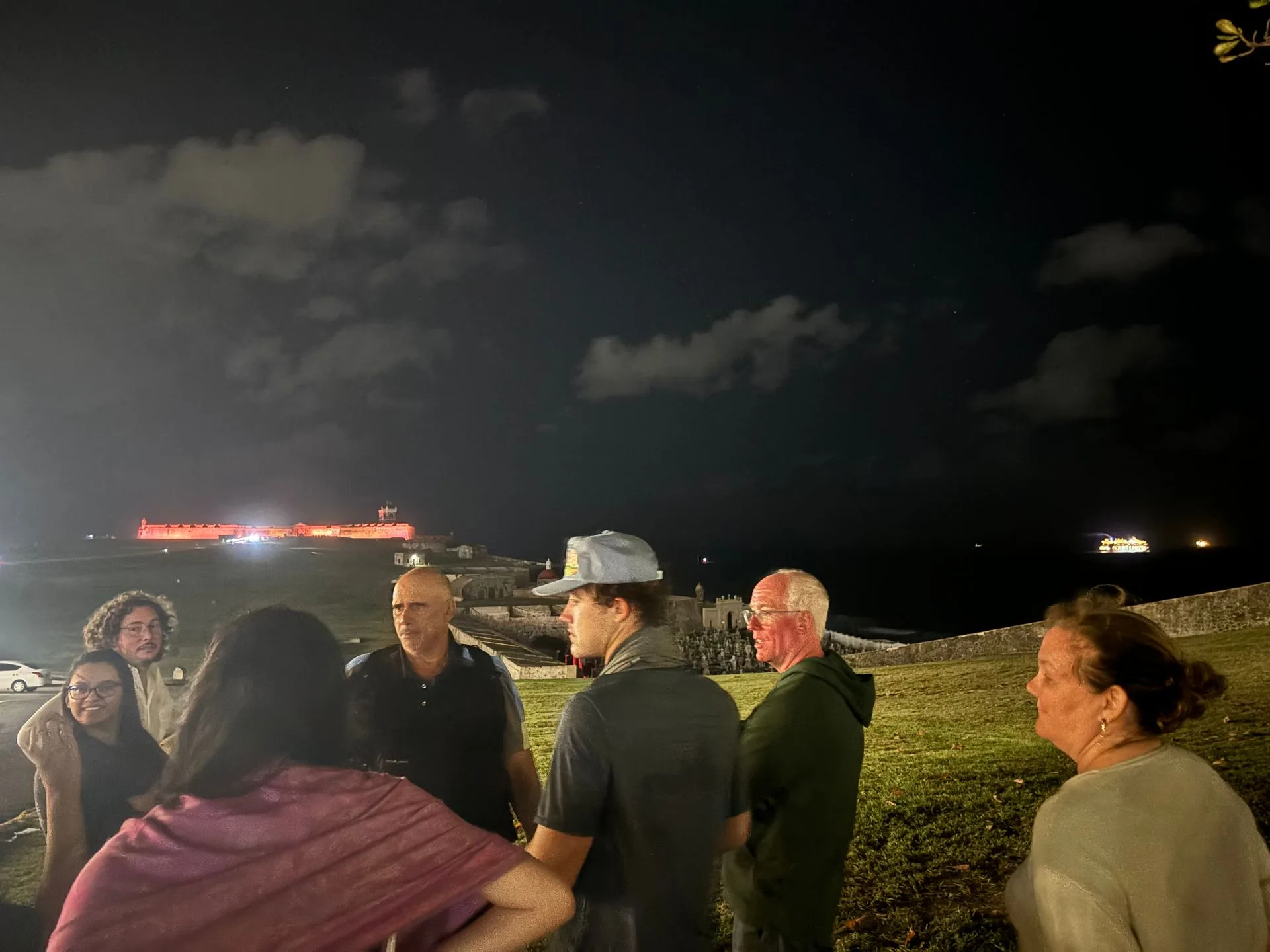A group stands in front of the old fort at night