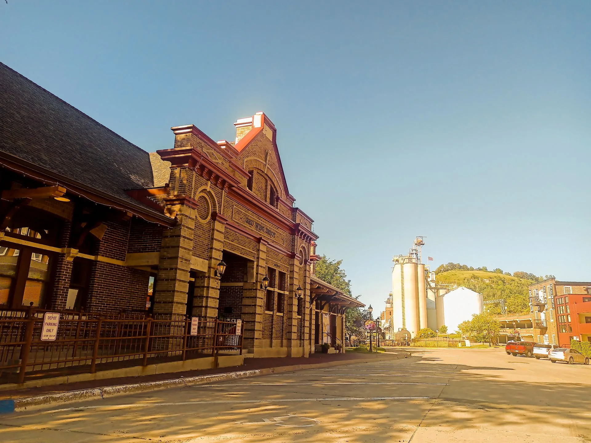 Historic brick building and silo on a sunny day. Empty street.