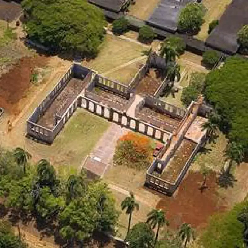 An aerial view of a large building surrounded by trees and grass.