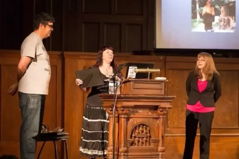 A woman stands at a podium giving a presentation to a group of people
