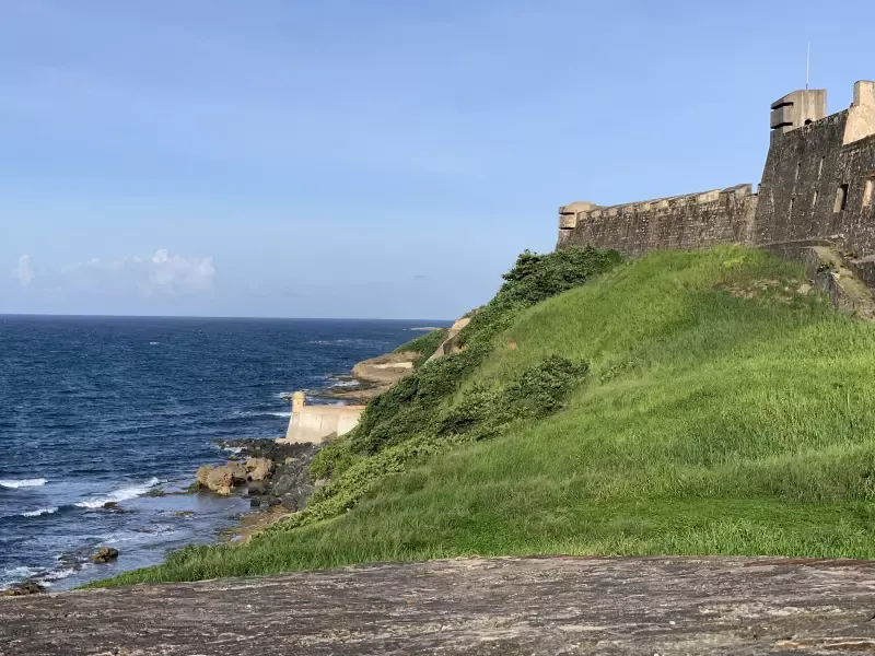 There is a castle on the cliff overlooking the ocean.