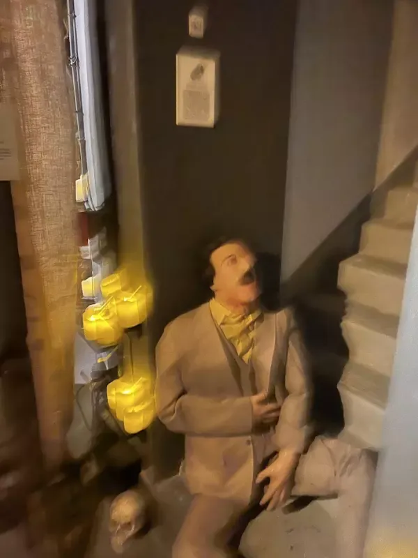 A man in a suit and tie is standing next to a staircase.