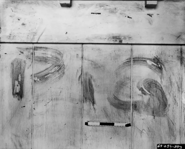 Black and white photo of a white surface with smudged letters 