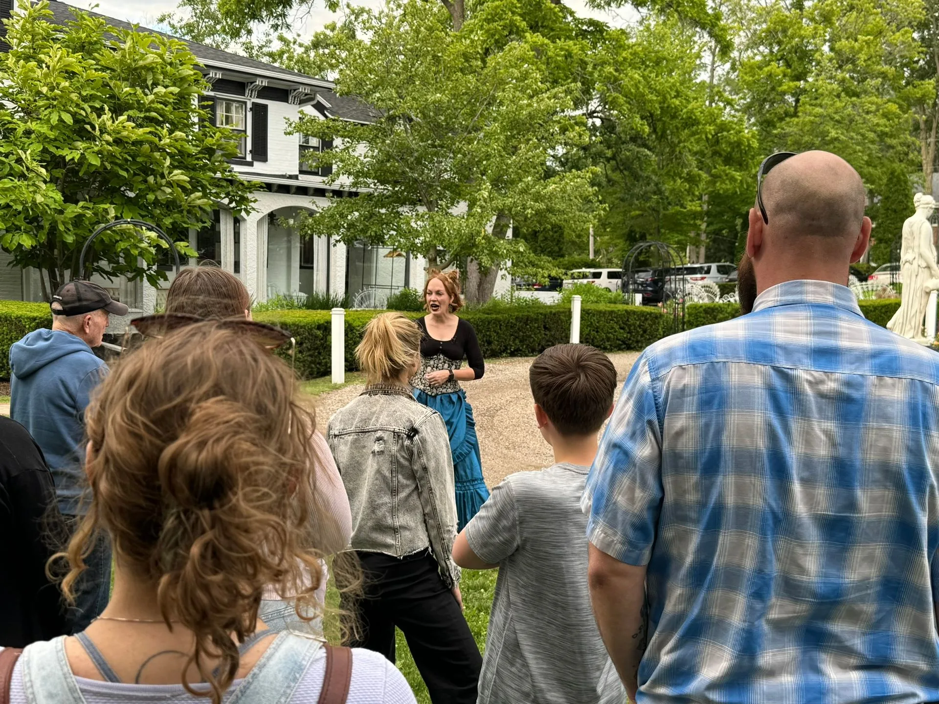 Ghost host Rita Mae Moore leading a Lake Geneva ghost tour in front of the Maxwell Mansion 