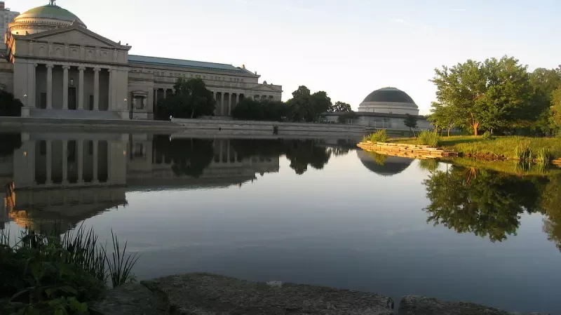 A large building is reflected in a body of water