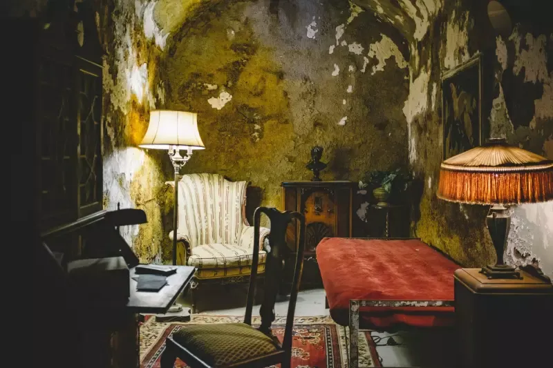 A living room with a couch , chair , lamp and piano.