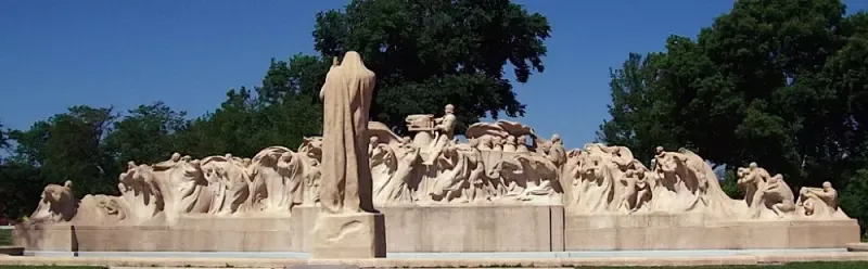 A large statue in a park with trees in the background