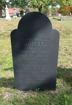 A black gravestone in a cemetery with the name butler on it.
