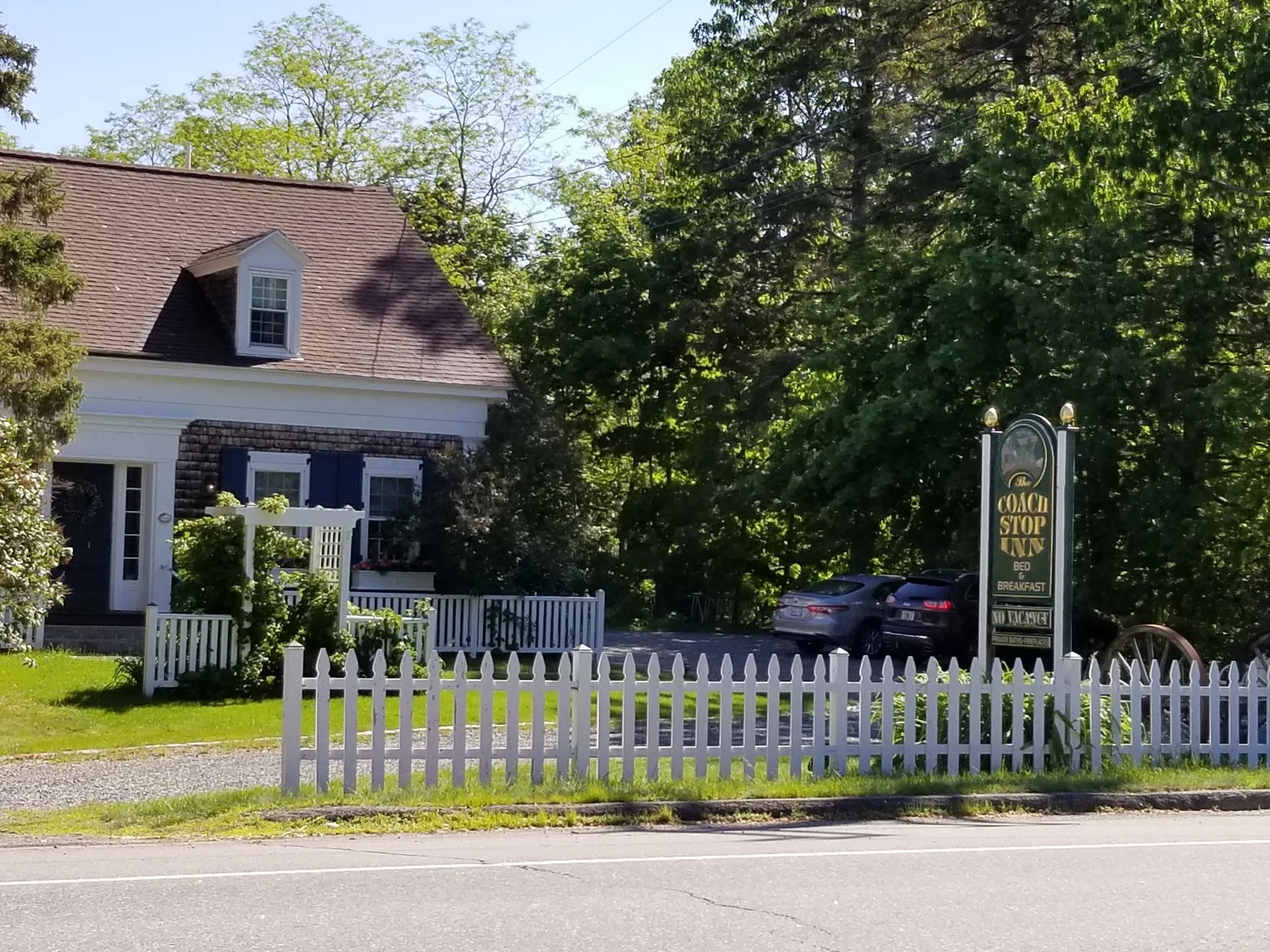 A white picket fence surrounds a house with a sign that says ' a place to stay ' on it