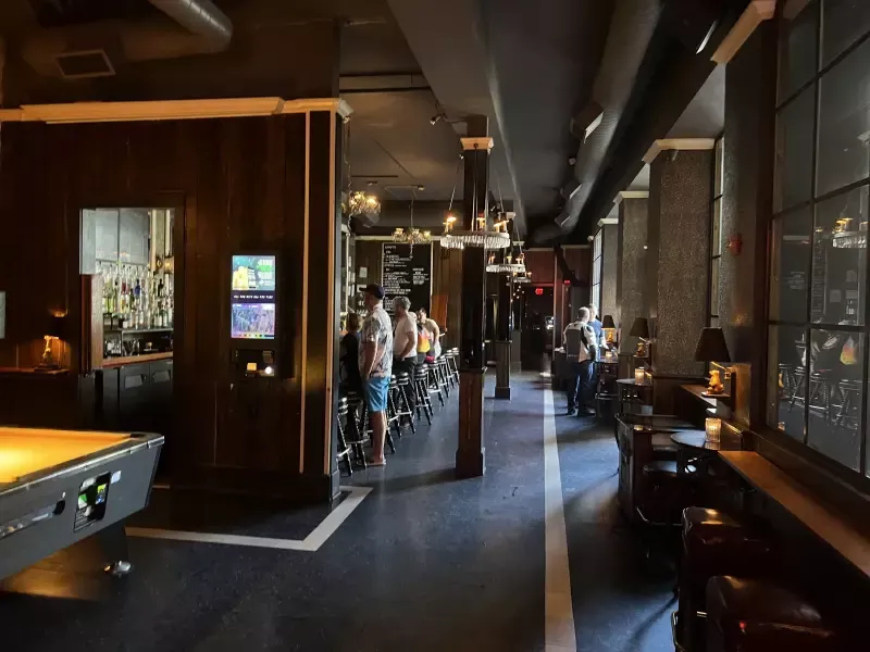 A long hallway with a pool table in the middle