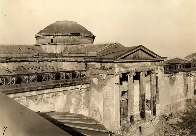 A black and white photo of an old building with a dome on top
