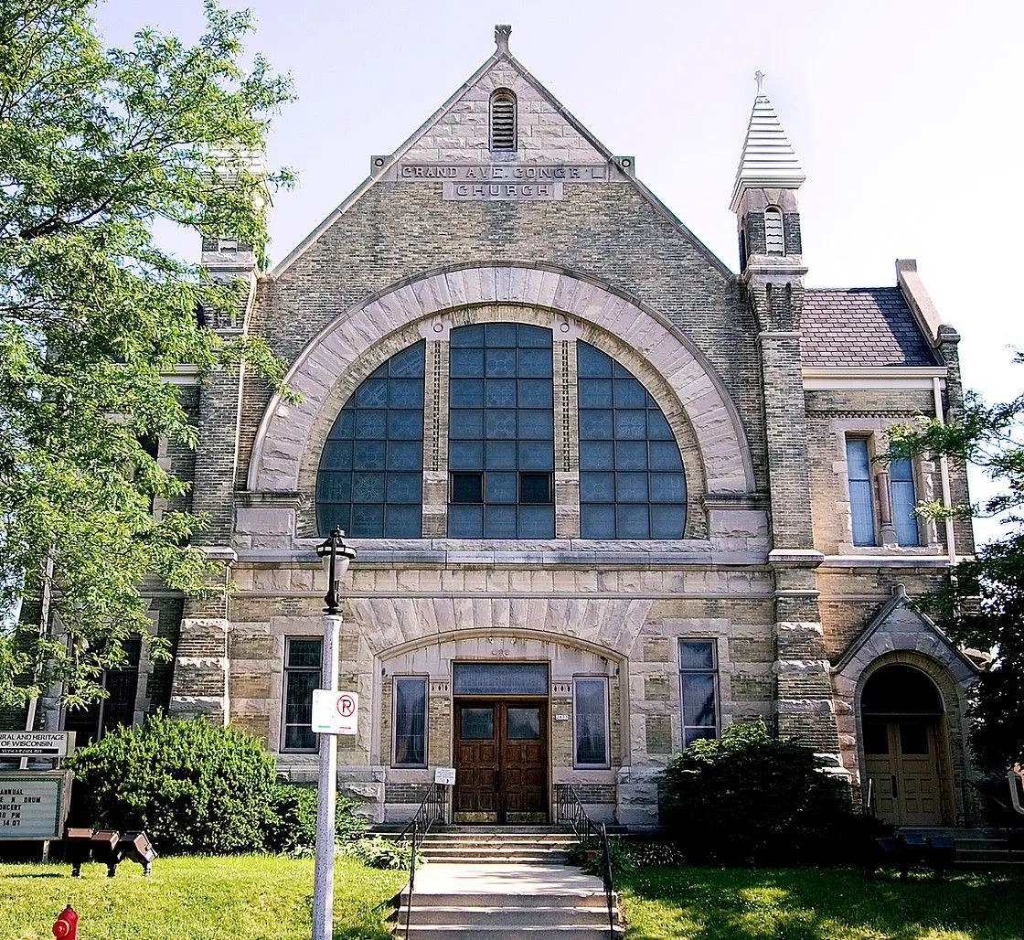 A large stone building with a no parking sign in front of it