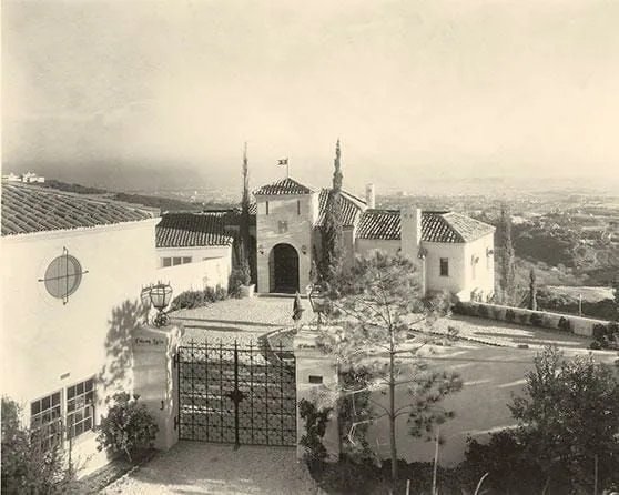 A black and white photo of a house on a hill