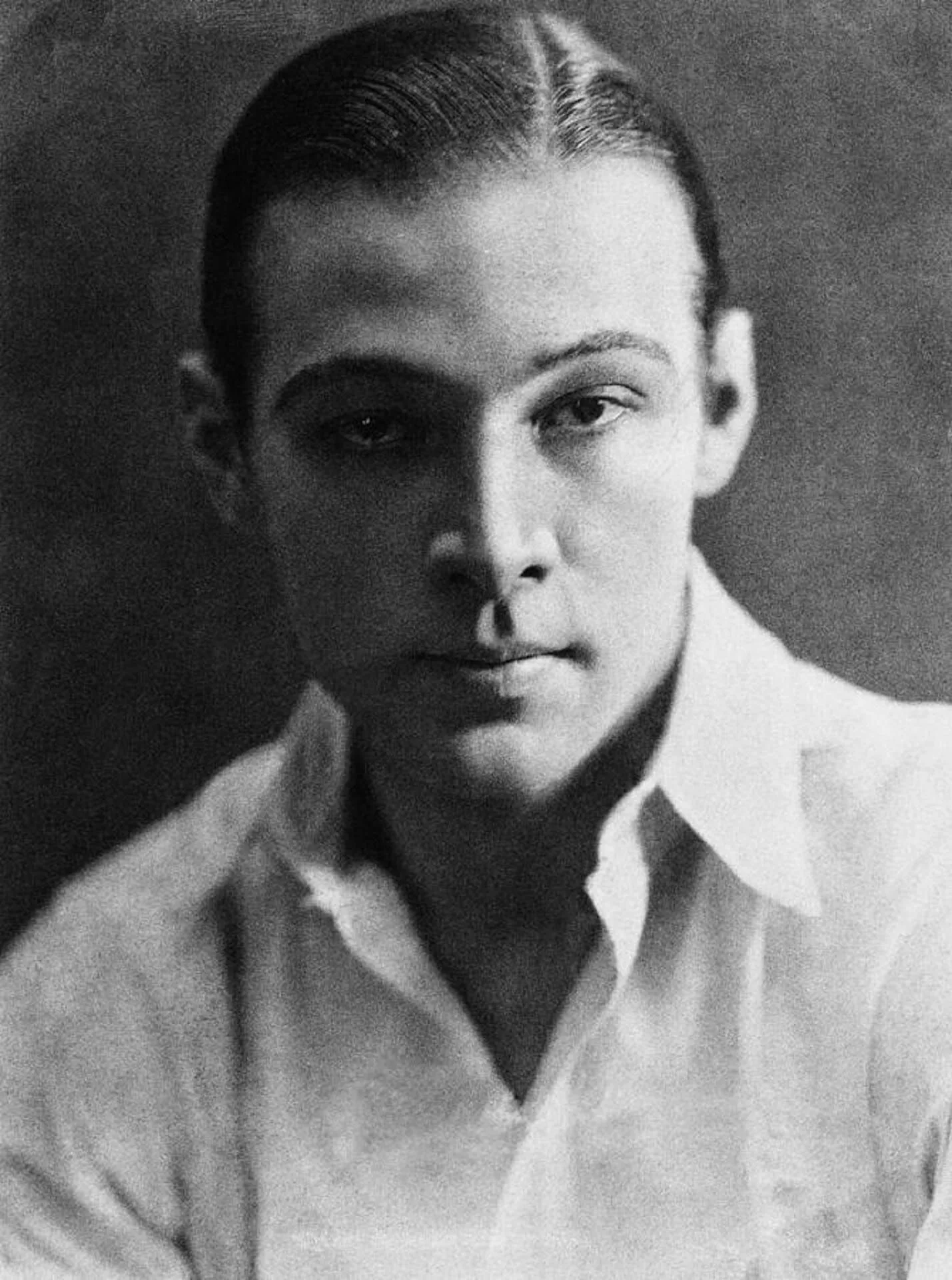 A black and white photo of a young man in a white shirt.