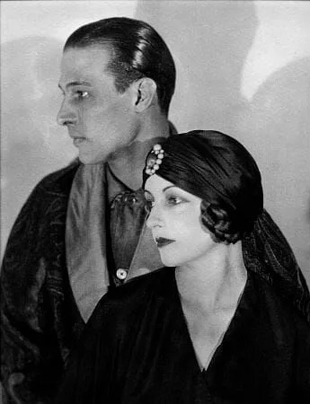 A man and a woman are standing next to each other in a black and white photo.