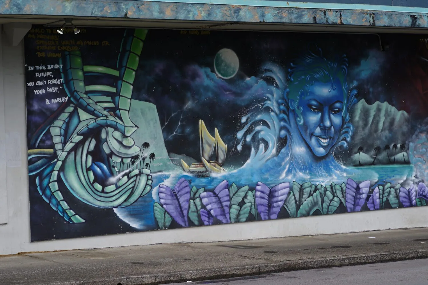 A mural on the side of a building shows a crab and a woman