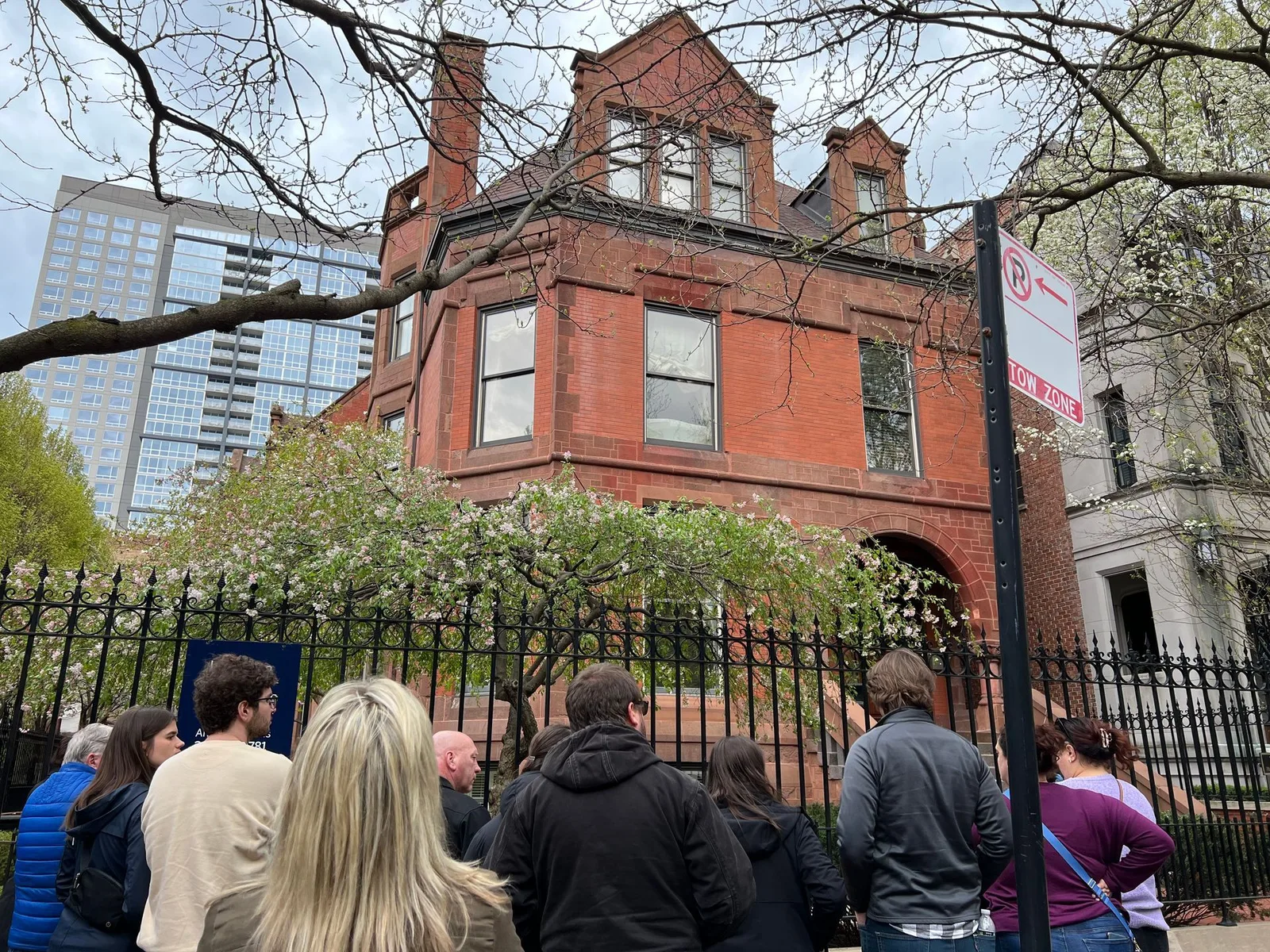 A group of people are standing in front of a large brick building